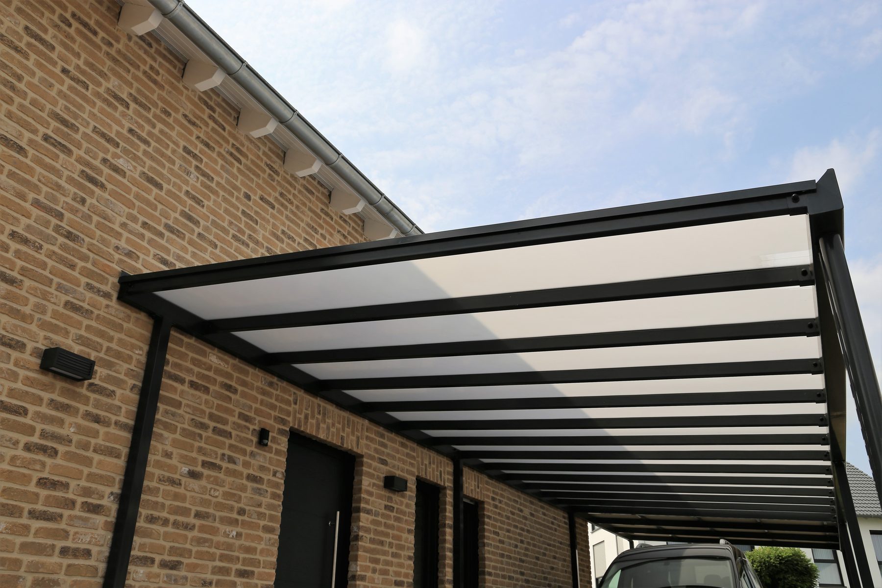 Terrassenüberdachung aus Aluminium an einem Klinkerhaus